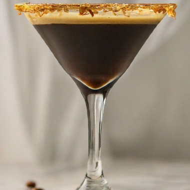 a photo of a coconut espresso martini with toasted coconut flakes on the rim